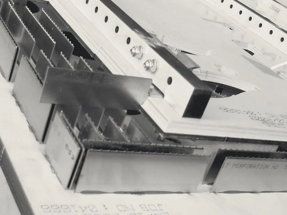 Close-up of stripping tooling: steel blades set into a plywood board