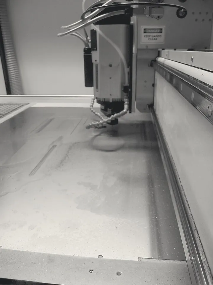 A milling head working over a sheet of stainless steel