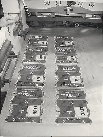 Phenolic counter plates laid out on the bed of a die-cutting press