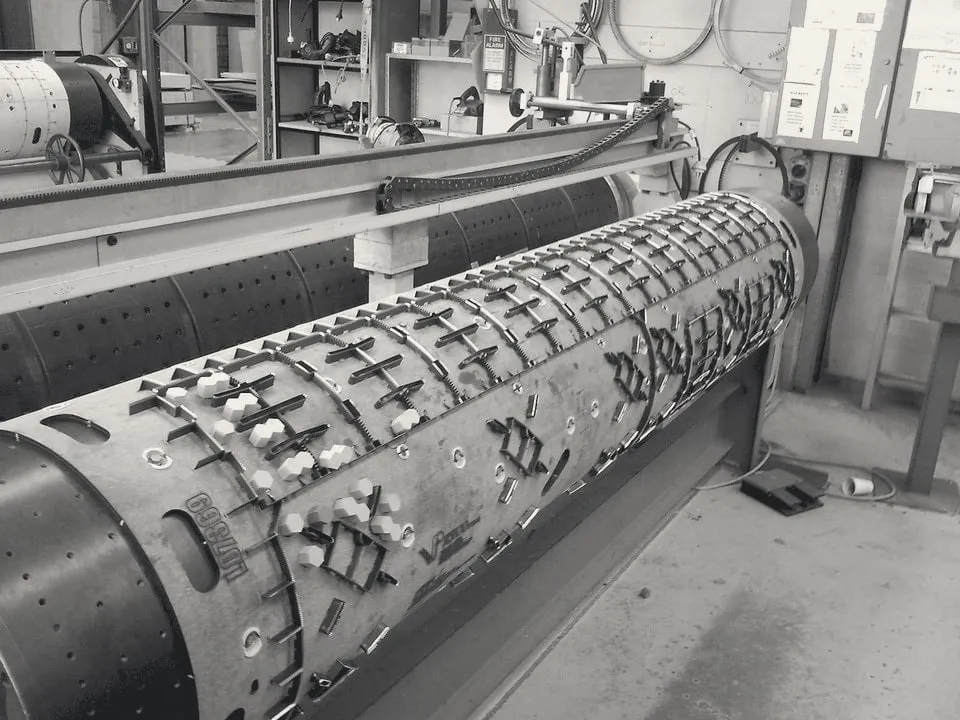 Rotary die on a stand in the workshop, set with steel rules and white ejection rubber